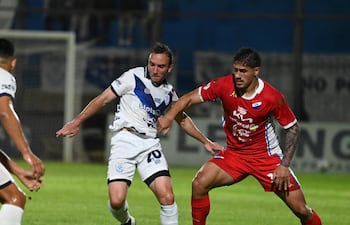 El mediocampista del Sportivo Ameliano, Valentín Larralde transporta el esférico ante la marca del volante de Nacional, Roberto Ramírez.