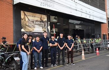Jóvenes protestan frente al edificio del Ministerio de Educación y Ciencias, con policías al fondo.