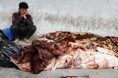 Un joven junto a los cuerpos de víctimas de un bombardeo israelí en la Ciudad de Gaza, este martes.