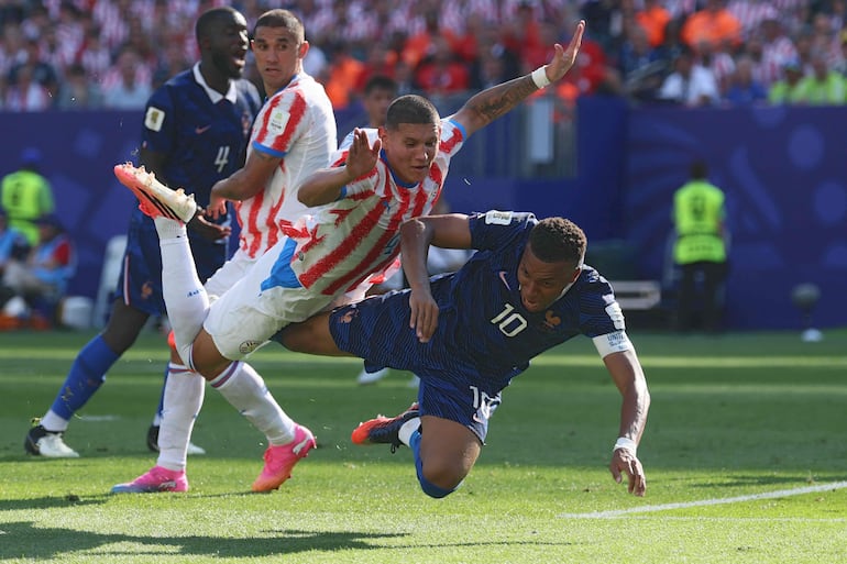 El defensor de Paraguay Juan José Cáceres y el delantero de Francia Kylian Mbappé caen al suelo durante el partido de fútbol de octavos de final de la Copa Mundial 2026 entre Paraguay y Francia en el Philadelphia Stadium en Filadelfia.