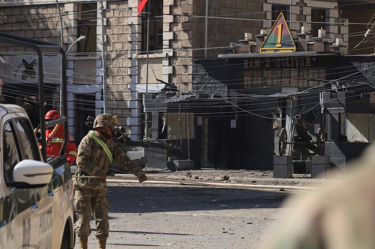 Integrantes de la Policía Militar de Bolivia custodian una calle afectada por una explosión este sábado, en Viacha (Bolivia). Sensaciones de incertidumbre y miedo predominaban entre los pobladores del municipio boliviano de Viacha, sobre todo los directamente afectados por las dos explosiones ocurridas en la víspera en un cuartel militar, que hasta el momento han dejado tres fallecidos, 14 desaparecidos y 84 heridos.