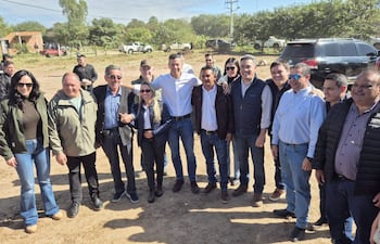 Santiago Peña y autoridades posan en la cabecera del precario aeropuerto de Carmelo Peralta