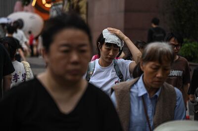 Personas cruzan una calle frente a un centro comercial en Guangzhou, en la provincia de Guangdong, en el sur de China.