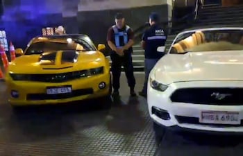 El Chevrolet Camaro, de color amarillo, y el Ford Mustang, de color blanco, que forman parte de los vehículos que fueron secuestrados por la Policía Federal.