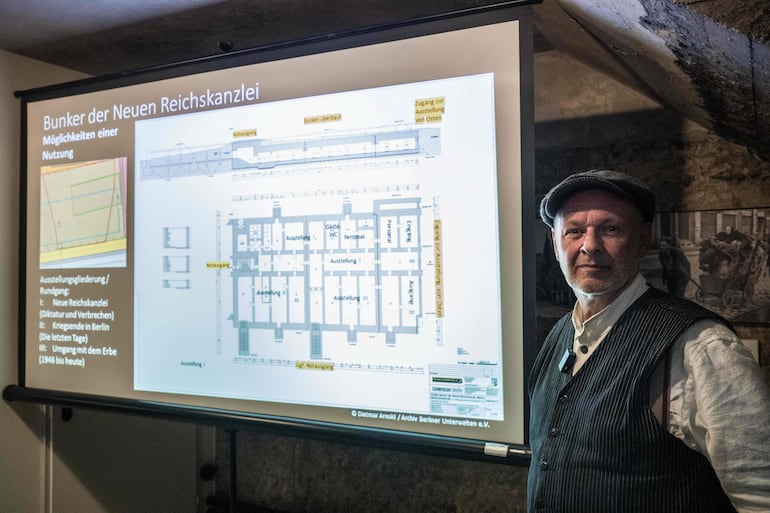 Dietmar Arnold, presidente de la asociación “Berliner Unterwelten” (Subterráneos de Berlín), posa junto a un mapa que muestra el búnker subterráneo de la Nueva Cancillería del Reich, en el distrito de Mitte, durante una conferencia de prensa en Berlín, el 11 de agosto de 2026.FP)