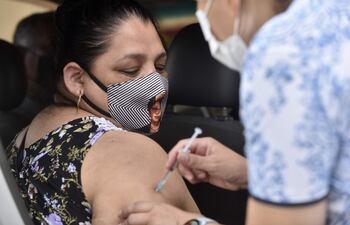 Mujer recibe dosis contra el COVID-19 en Asunción.