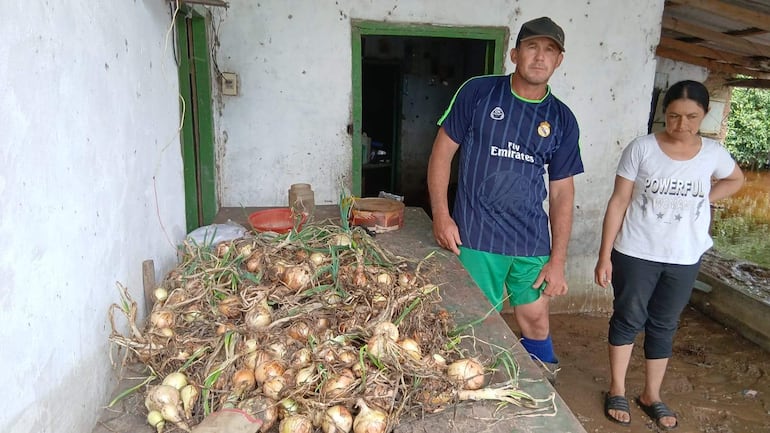 Hombre con camiseta del Real Madrid y mujer con camiseta blanca 'POWERFUL WOMAN' en un entorno agrícola desordenado.
