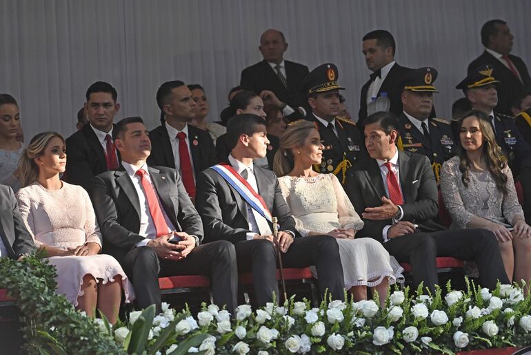 En compañía de su esposa (d), Silvio Beto Ovelar conversa con la primera dama, Leticia Ocampos, durante el desfile militar llevado a cabo ayer. 
