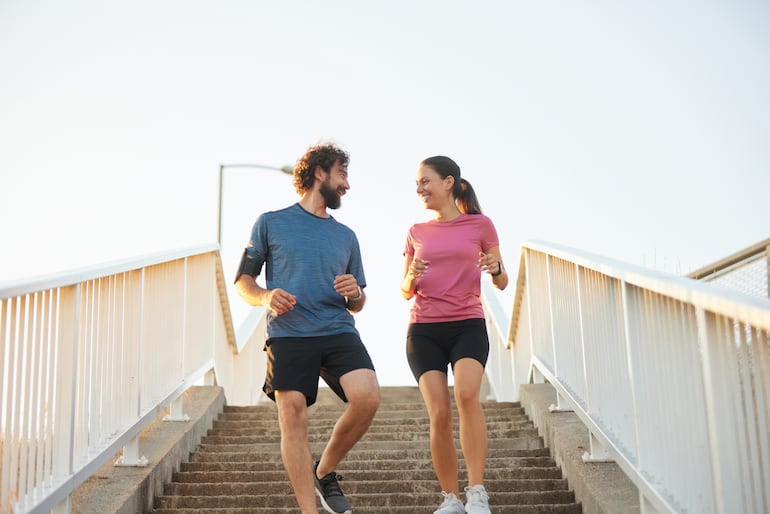 Un hombre y una mujer bajan escaleras. Concepto de actividad física.