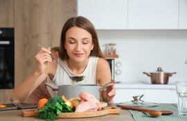 Mujer cocinando un caldo.