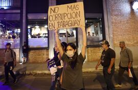 Una mujer sostiene un cartel durante una manifestación este domingo, en Asunción.