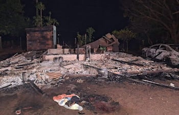 Sitio del Puesto Policial N° 4 en Naranjito, con estructuras colapsadas y un vehículo parcialmente quemado en la noche.