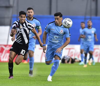 Lorenzo Melgarejo y Jorge Moreira pelean por la posesión del balón en el Arsenio Erico