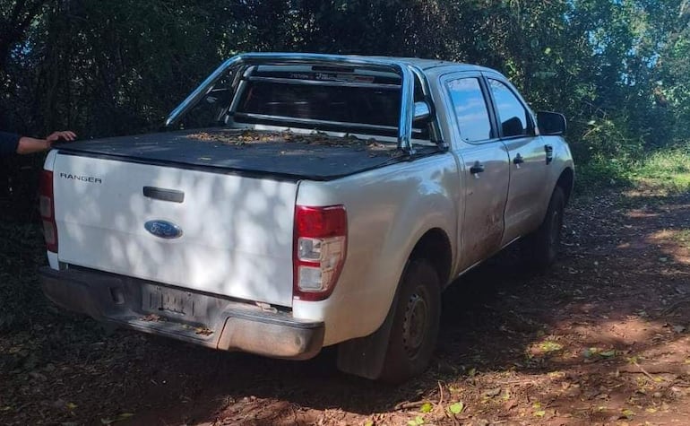 Camioneta Ford Ranger blanca estacionada en un camino rural rodeado de vegetación densa.