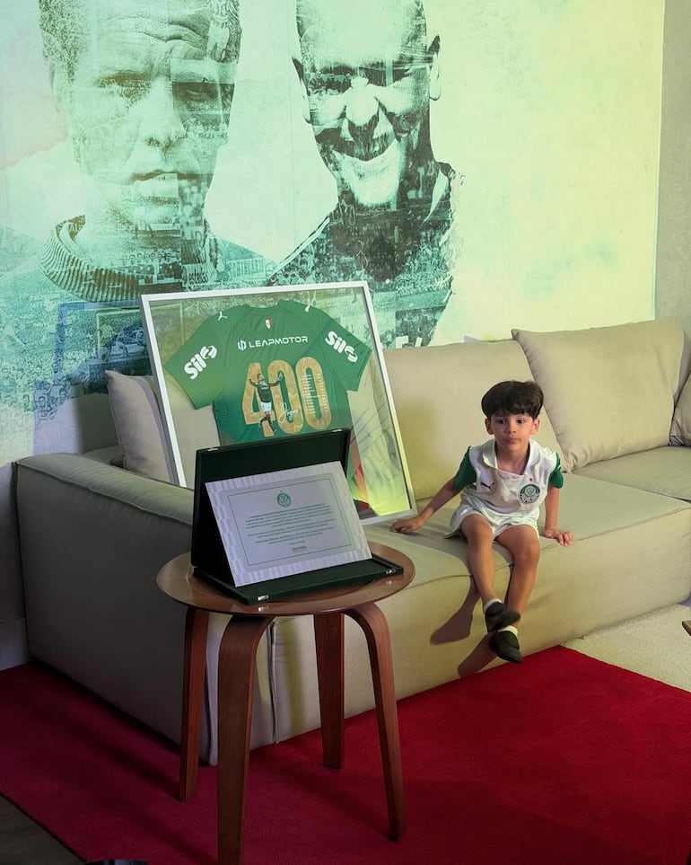 El tierno Lucca Emmanuel posando con la camiseta y el cuadro de reconocimiento que recibió su papi Gustavo Gómez. (Instagram/Gustavo Gómez)