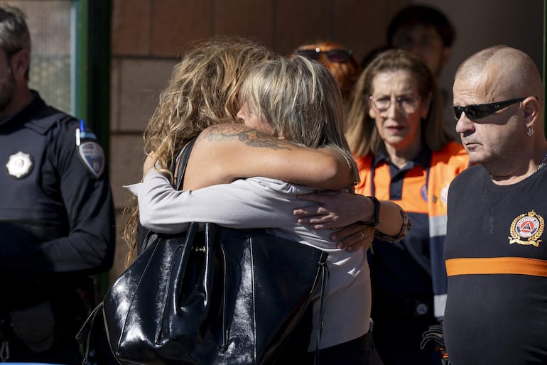 Dos mujeres se abrazan este miércoles en el pabellón polideportivo del municipio que se ha habilitado como espacio principal para la llegada de los heridos más leves del accidente en el que han colisionado un tren AVE con otro de Iryo son atendidos en el pabellón municipal de Urda (Toledo).