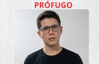 Hombre con gafas y camiseta negra, mirando a la cámara, con el texto 'PRÓFUGO' en rojo y sello del Gobierno del Paraguay.