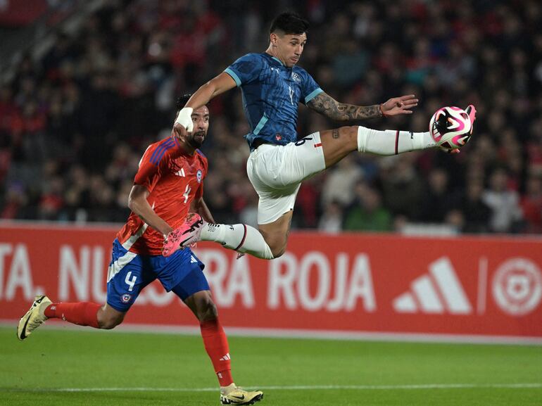 Adam Bareiro (c), jugador de la selección paraguaya, domina el balón durante el amistoso internacional frente a Chile en el estadio Nacional, en Santiago, Chile.