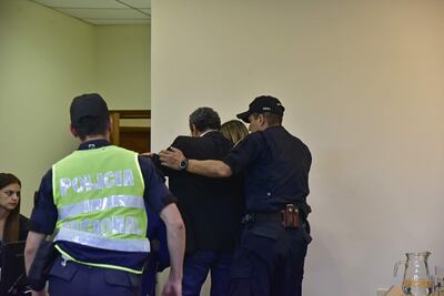 Hugo Javier González, acompañado por un familiar, es llevado por policías, tras conocer la sentencia.