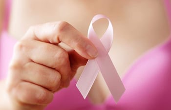 Mujer y lazo rosa, símbolo de la lucha contra el cáncer de mama. ARCHIVO.