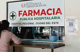 Mujer de espaldas frente al mostrador de la farmacia.