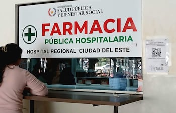 Mujer de espaldas frente al mostrador de la farmacia.