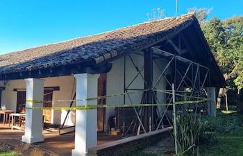 Fachada de edificio histórico en restauración con andamios y cintas de precaución, sin personas visibles.
