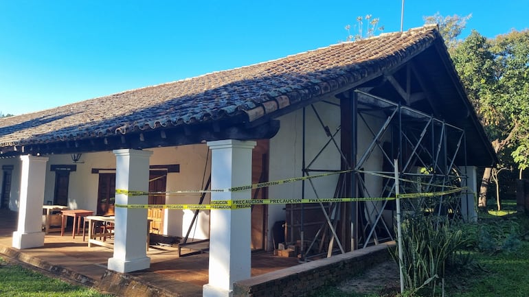 Fachada de edificio histórico en restauración con andamios y cintas de precaución, sin personas visibles.