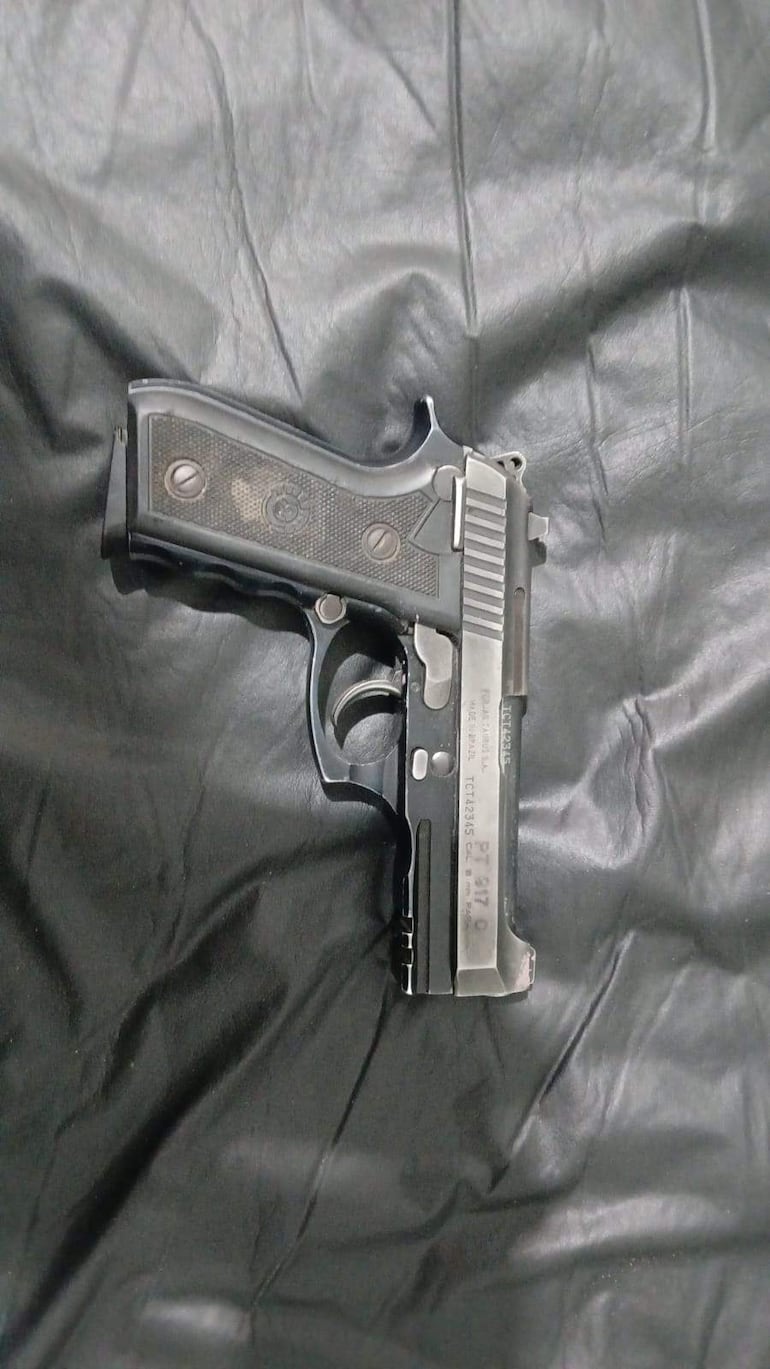 Pistola Taurus de 9 mm sobre superficie negra, enfocada en su diseño metálico y empuñadura texturizada.