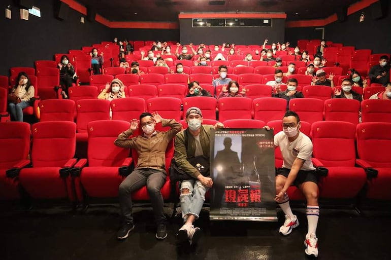 Asistentes a una de las funciones de "Morgue" sostienen el afiche internacional de la película en Taiwán.