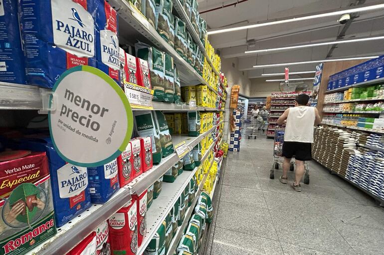 Personas realizan compras en un supermercado de Buenos Aires. La inflación golpea a la población, mientras el nuevo gobierno de Javier Milei afronta una protesta masiva. 