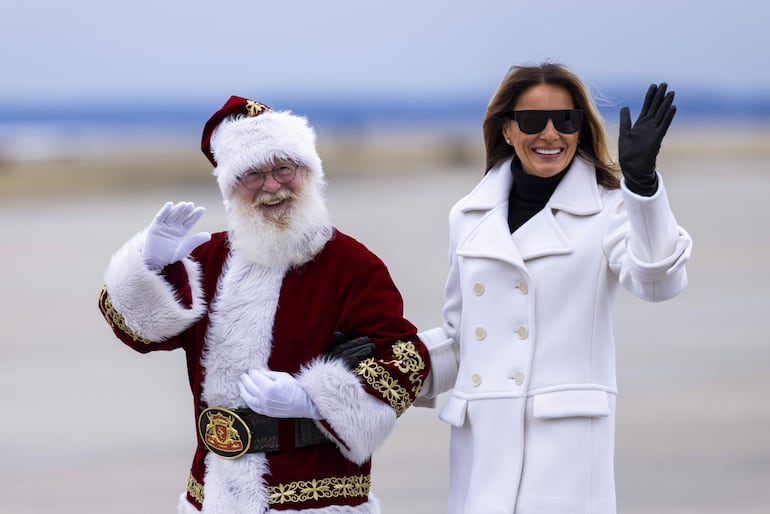 ¡Elegantísima! La primera dama estadounidense Melania Trump de brazos de Papá Noel. (EFE/EPA/JIM LO SCALZO)