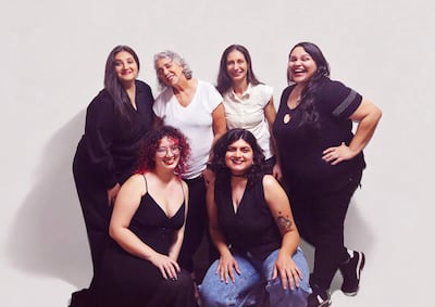 Seis mujeres sonrientes, destacando sus diferentes estilos de cabello y vestimenta, posan juntas en un fondo claro.