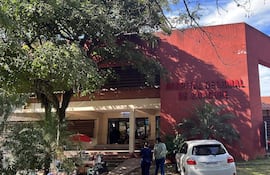Fachada del Hospital Regional de Caacupé, edificio moderno de paredes rojas, sin personas claramente visibles en la entrada.