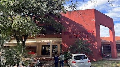Fachada del Hospital Regional de Caacupé, edificio moderno de paredes rojas, sin personas claramente visibles en la entrada.