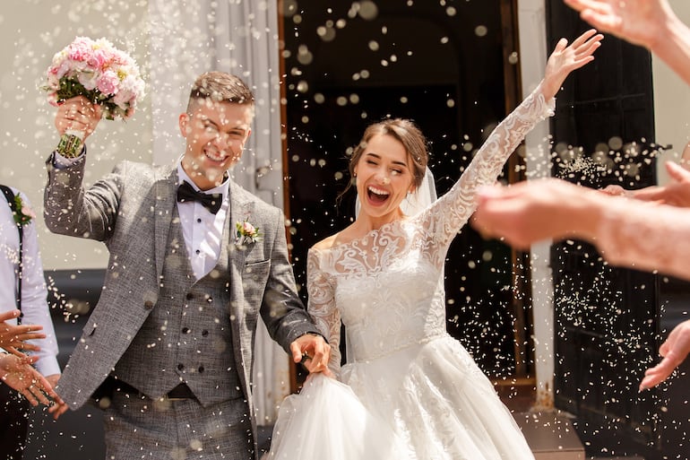 Invitados tiran arroz a pareja de recién casados.