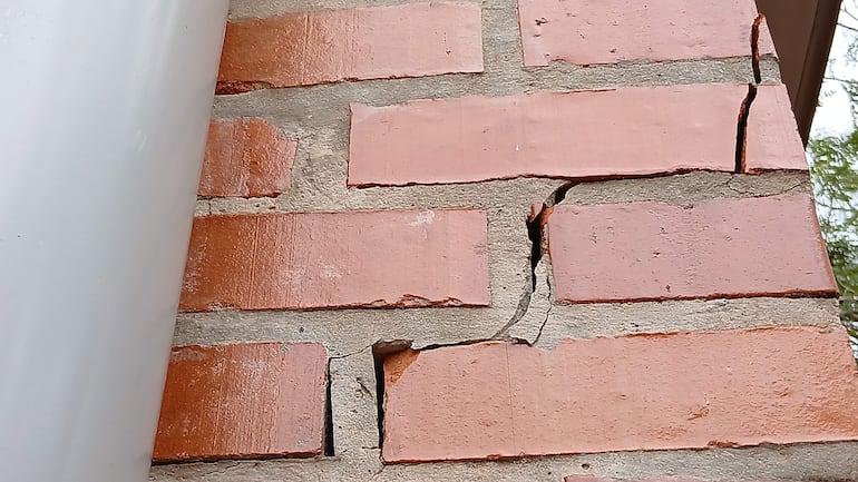 Sección de pared del Centro Nefrológico de Hernandarias con grietas visibles y ladrillos de color terracota.