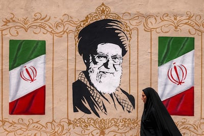 Una mujer camina junto a un mural que retrata al fallecido líder supremo iraní Alí Jameneí, en Teherán.