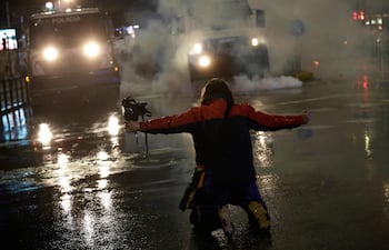 Un manifestante se arrodilla frente a un vehículo policial durante una protesta antigubernamental frente al edificio del Parlamento en Tirana el 20 de febrero de 2026.