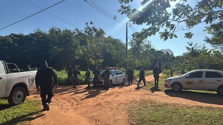Grupo de fuerzas de seguridad en un camino de tierra, con uniformes oscuros y armamento, rodeados de vegetación.