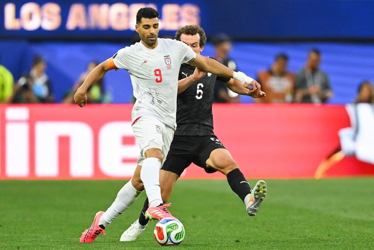 El delantero de Irán, Mehdi Taremi, y el centrocampista de Nueva Zelanda, Joe Bell, luchan por el balón durante el partido de fútbol del Grupo G de la Copa del Mundo 2026 entre Irán y Nueva Zelanda en el Los Angeles Stadium en Inglewood.
