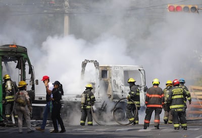 Integrantes del Cuerpo de Bomberos de Guadalajara intentan apagar un vehículo incendiado este domingo, en Guadalajara (México). El líder del Cartel de Jalisco Nueva Generación (CJNG), Nemesio Oseguera Cervantes, alias El Mencho, uno de los capos más buscados por EE.UU., fue abatido durante un operativo con fuerzas federales.