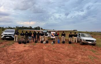 La presunta narcoavioneta boliviana, junto con los cuatro detenidos, las dos camioneta y doce bidones de combustible incautados.