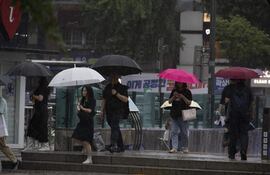 Personas caminan con paraguas en medio de una intensa lluvia en la plaza Gwanghwamun de Seúl, Corea del Sur.