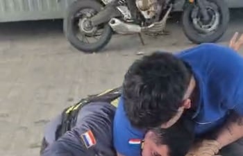 Un motociclista y un ante de la Patrulla Caminera en una pelea.