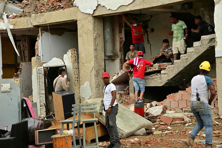 Personas rescatan pertenencias domésticas de un edificio residencial dañado en Caraballeda, estado de La Guaira, Venezuela, el 11 de julio de 2026.