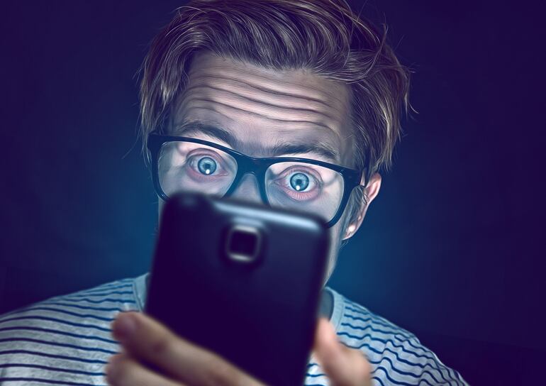 Hombre mirando su celular.