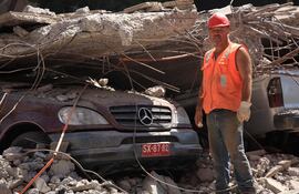 Chile: trabajador cerca de un SUV Mercedes Benz en un estacionamiento aplastado por el piso de un edificio durante el terremoto de 8,8 del 27 de febrero de 2010.