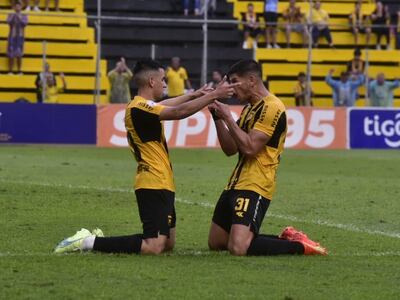 Romeo Benítez (i) y Facundo Barceló, jugadores de Guaraní, celebran un gol en el partido frente a Resistencia por el fútbol paraguayo.