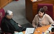 Esperanza Martínez de Portillo, con suéter claro y pañuelo, habla inclinada hacia adelante en un ambiente legislativo.
